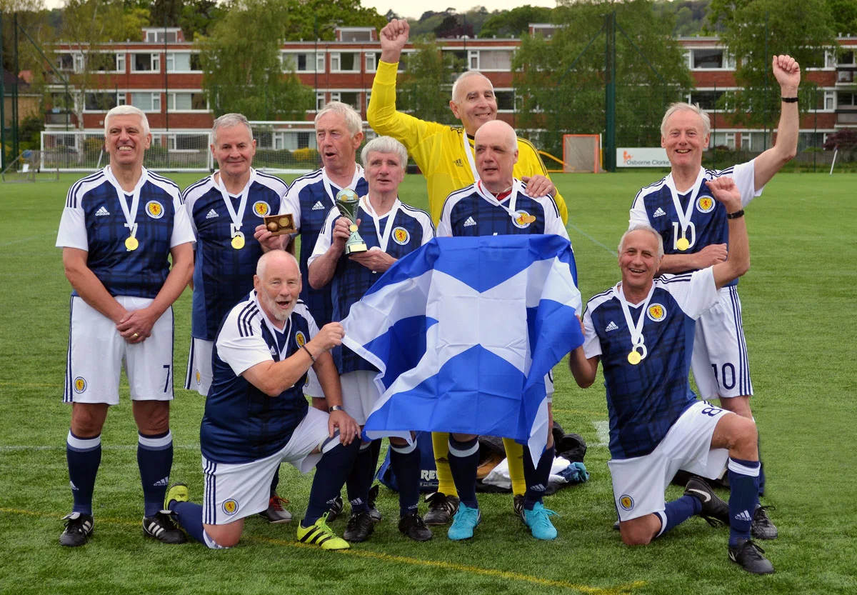 Harry Harvie holds the World Cup and celebrates with his victorious squad.