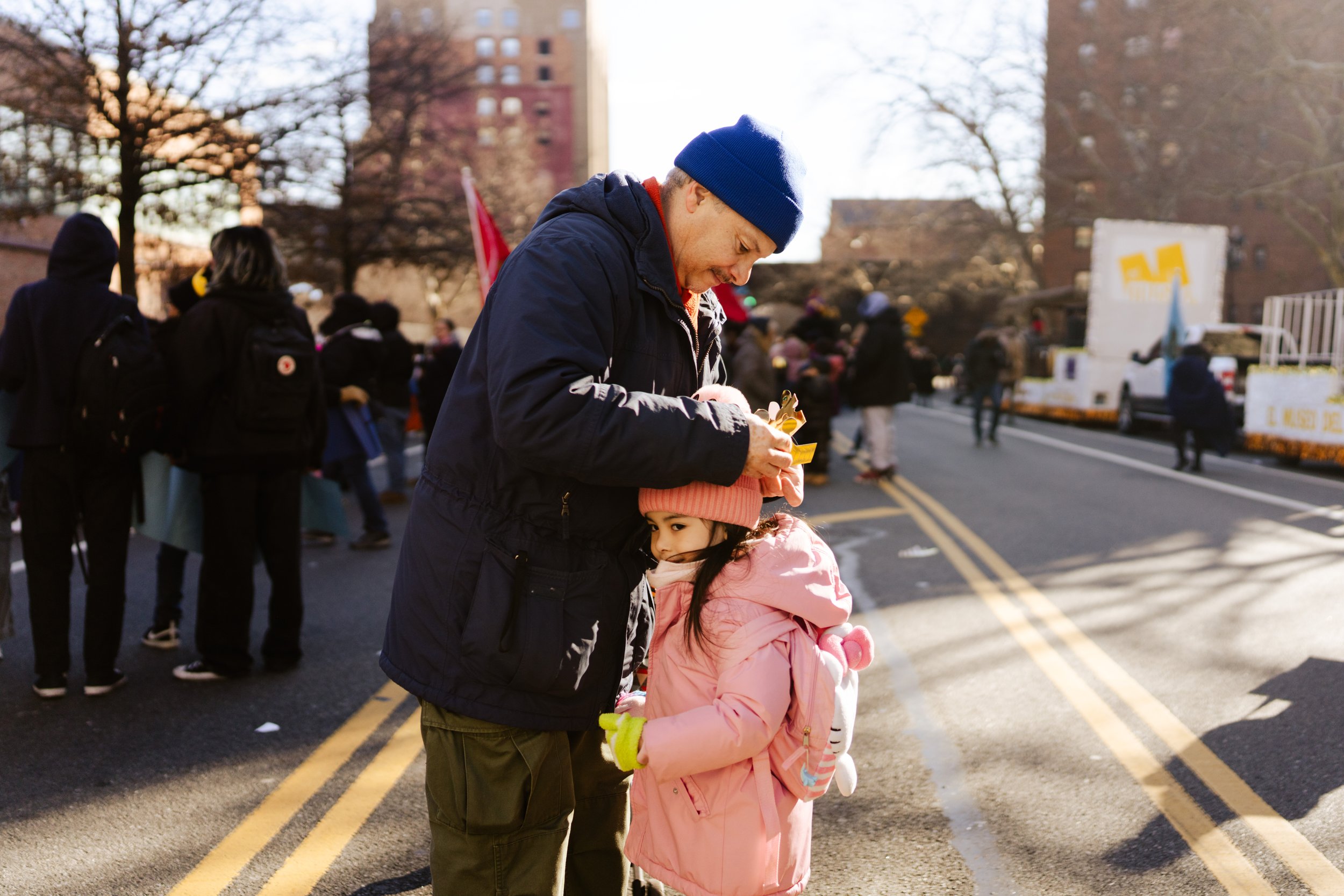A father fixes his daughter’s paper crown at East Harlem's Three Kings Day Parade