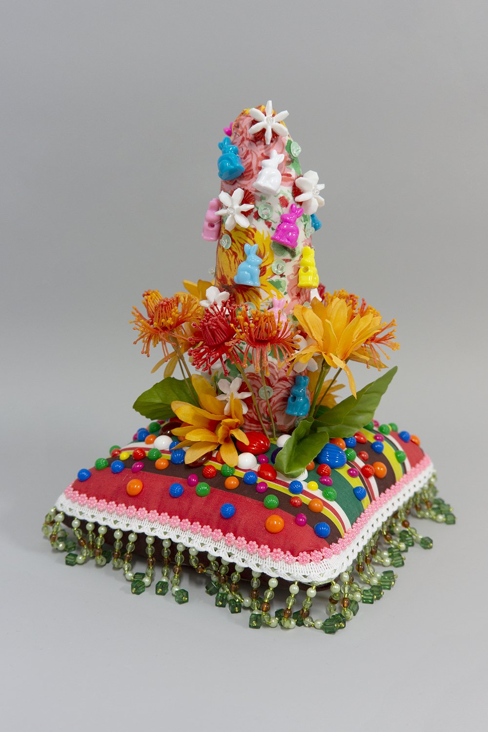   Untitled,  2022, Plastic beads and sequins, found fabric, trim, fabric and plastic flowers, cabochons, polyester batting, thread, 10 x 10.5 x 10.5” 