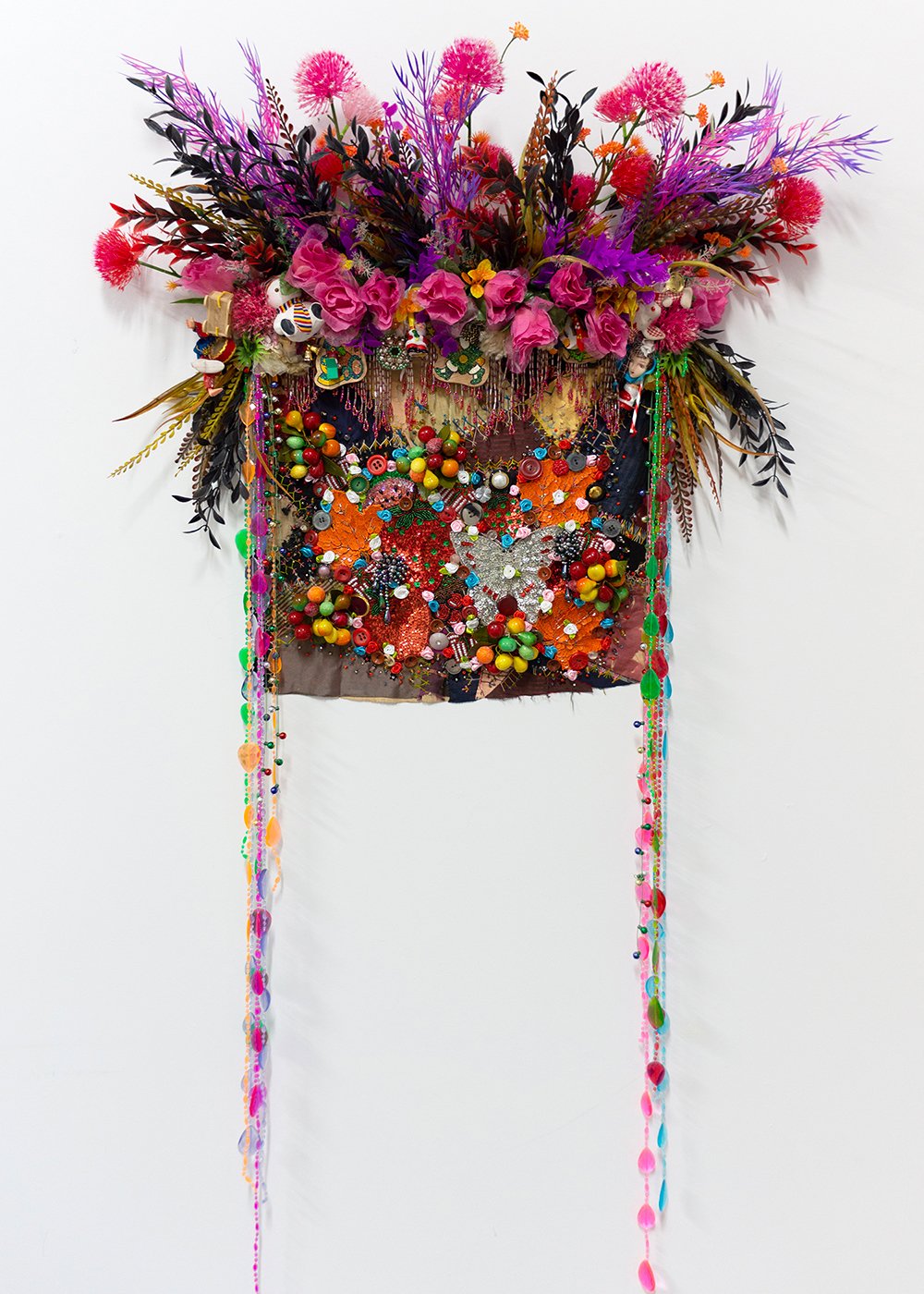   Shroud #12 (study) , 2023, Found 'Crazy' quilt ca. 1900, trim, fabric and plastic flowers and fauna, toys, ornaments, costume jewelry, beads, sequins, buttons, plastic curtain, fabric, pine, 57 x 32 x 9” 