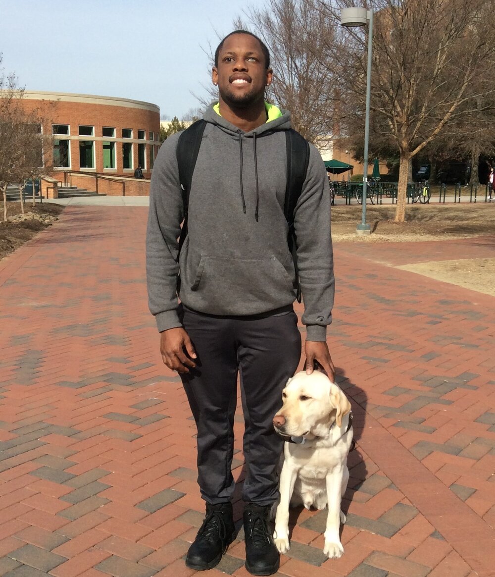 student in a grey hoodie with a dog