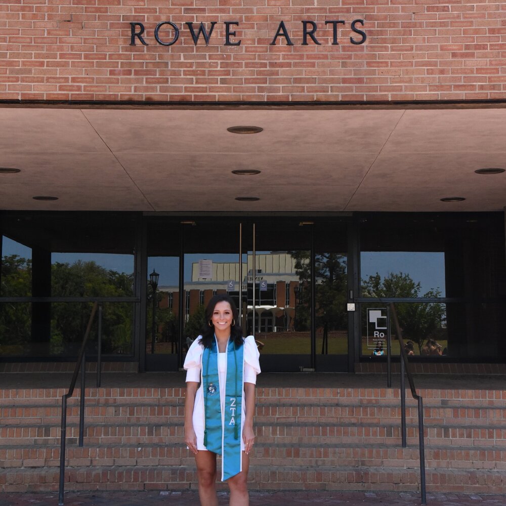 student standing in front of rowe arts