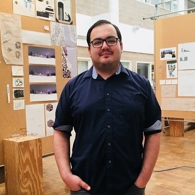 student standing in front of a project in storrs