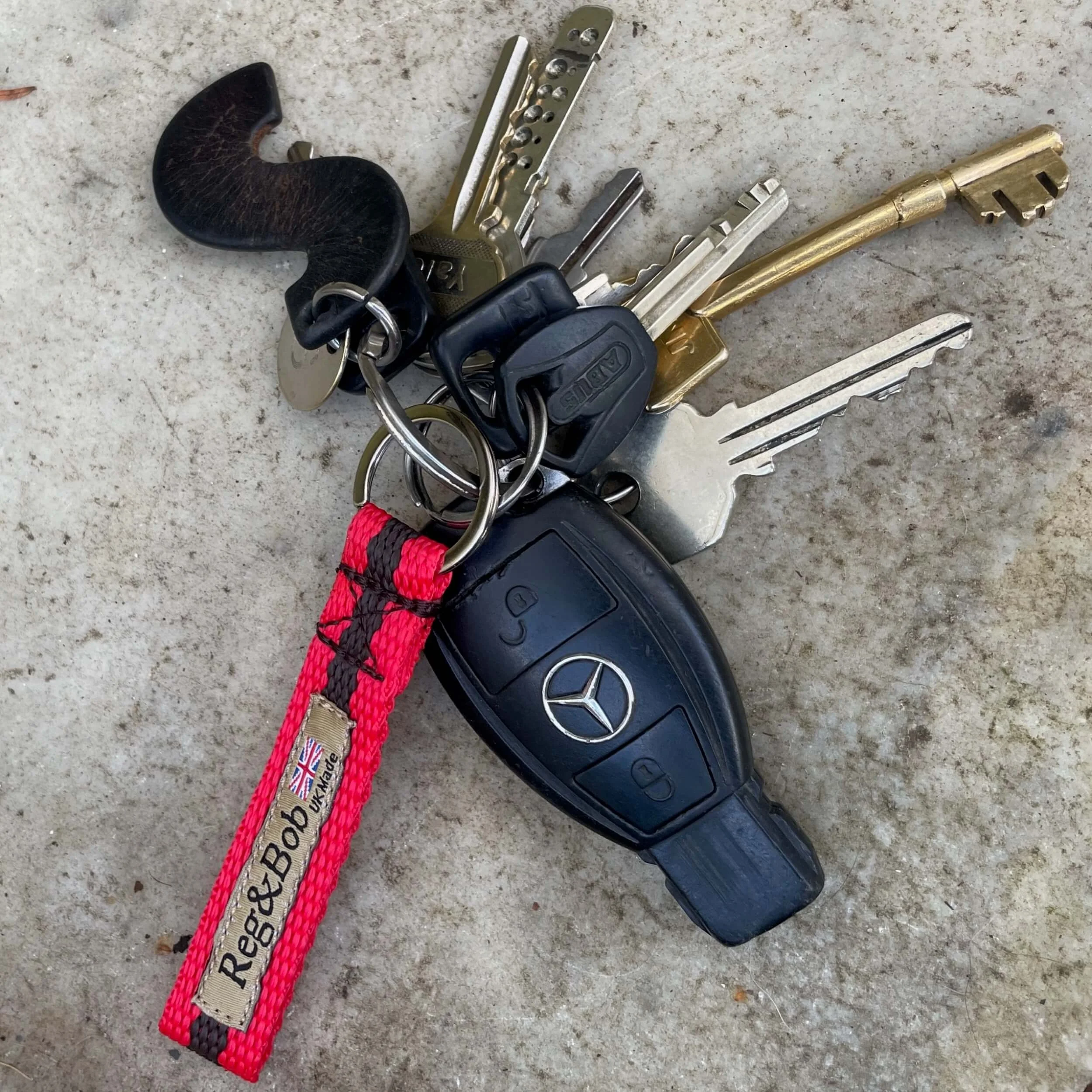 red keyring by Reg&Bob with keys on a stone step