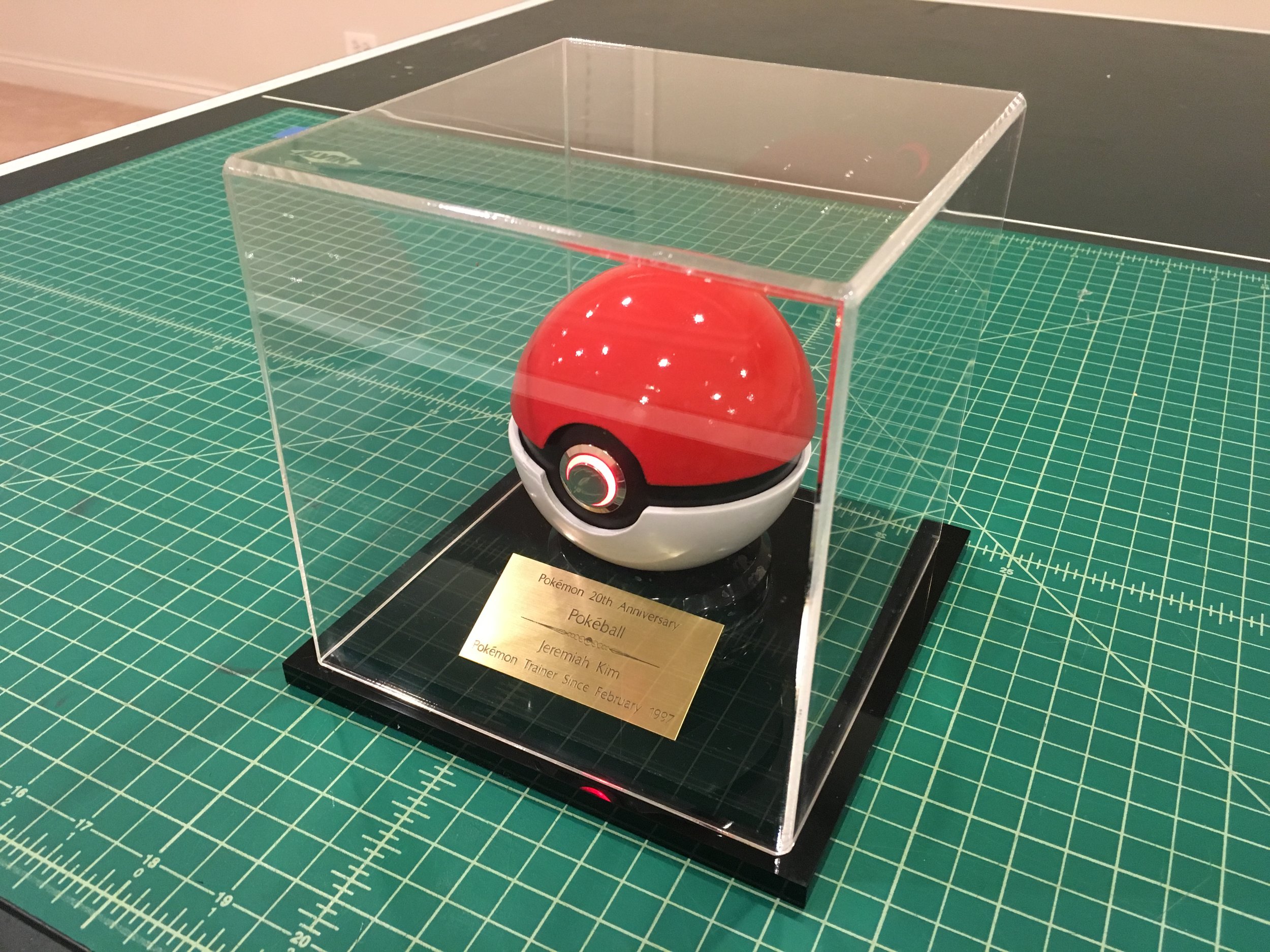 A custom acrylic display case with a plaque was created to display the pokéball in a place of honor.