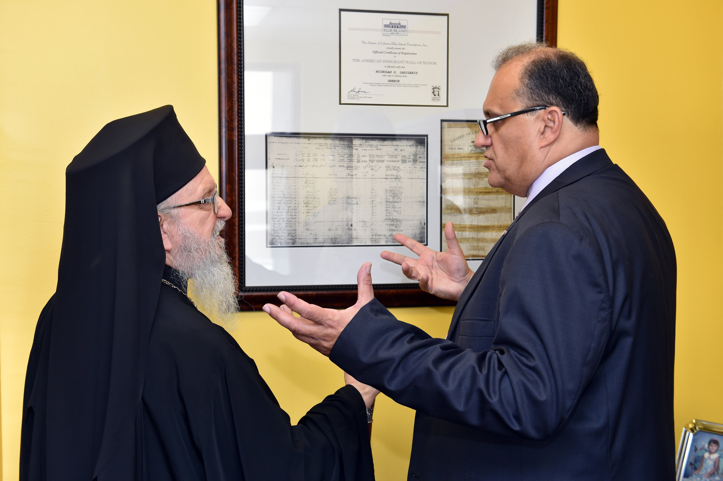  Nick Larigakis shows His Eminence Archbishop Demetrios of America archival documents of the journey of his family from Greece to America. 