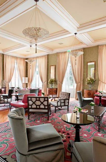 Four Seasons Room // Capitoné velvet armchairs made by Larforma, sofas, bergèrés chairs, curved sofas and a circular leather bench, some rooster stand tables, and plenty of soft cushions make up an eclectic furnishings set and form various seating areas.. Photo © Vidago Palace, Portugal