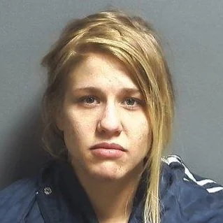 Woman claims she didn't know a wanted man was hiding inside a wall in her home