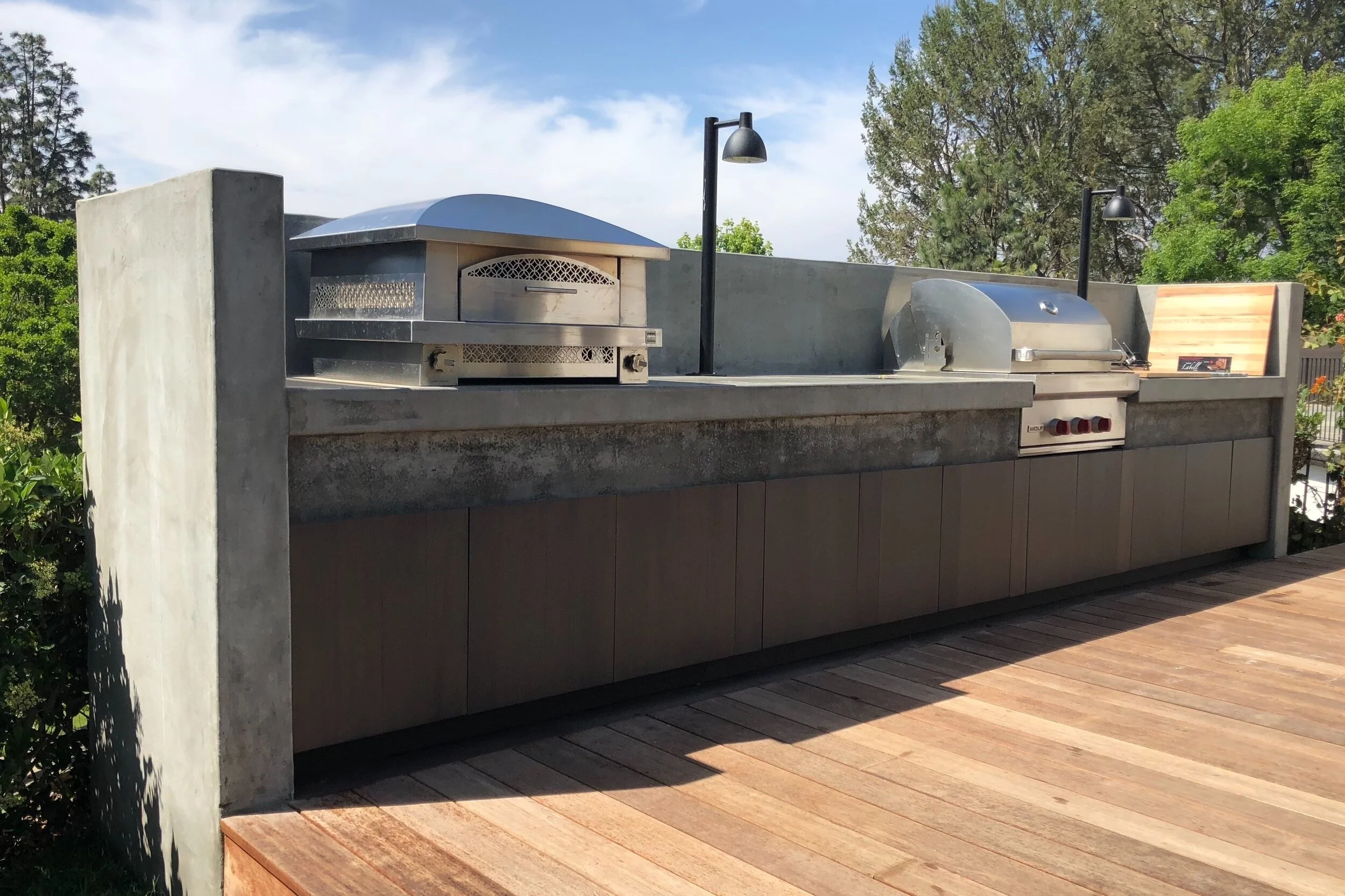  Concrete outdoor kitchen complete with pizza oven and grill and plenty of storage space. 