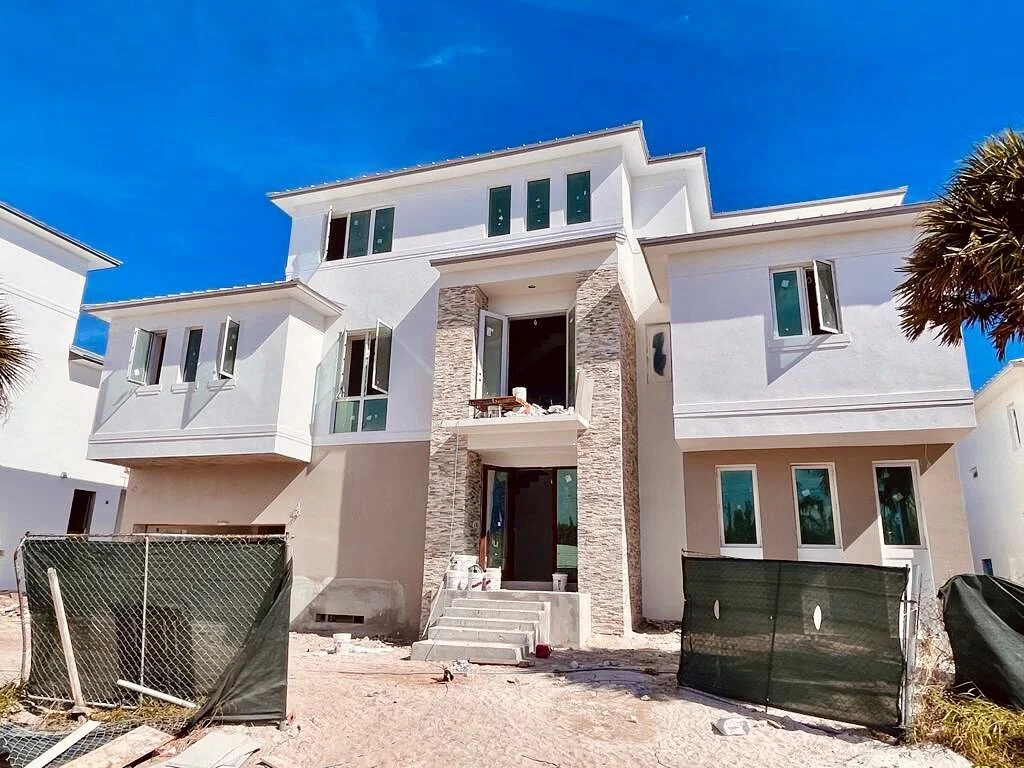 What a difference paint &amp; stucco make. The stone feature wall draws the eye upward, making the house appear taller! #verobeach #beachfront #taupe