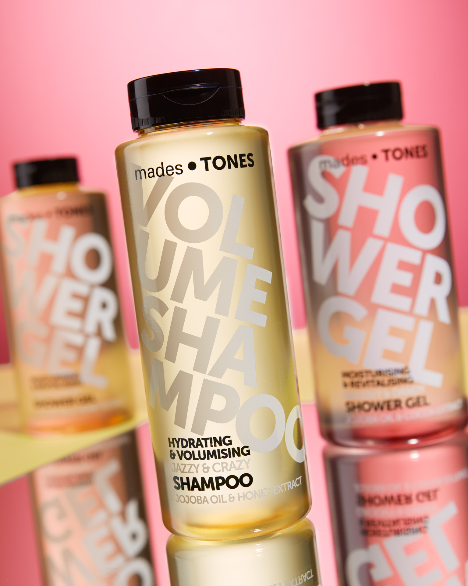 Product foto van shampoo en douche producten met roze en gele kleuren