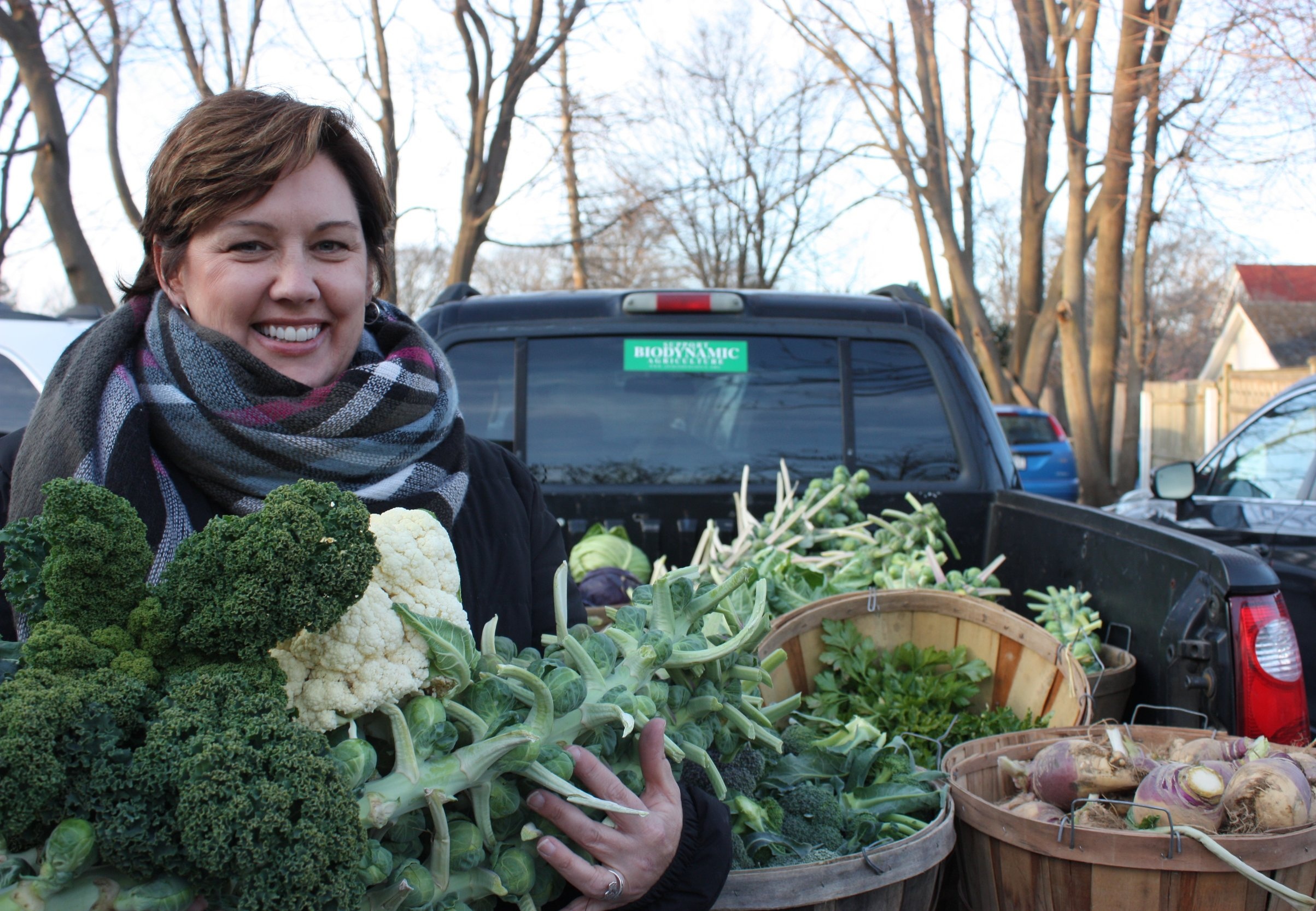 Cathy Demeroto, Executive Director of CAST, with an armful of donated vegetables.