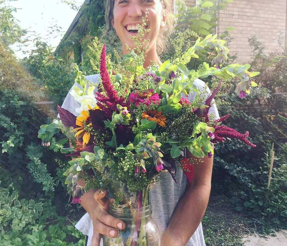 The Veg Yard founder Maddy Torraca Jones holds a bouquet of flowers from the farm’s flower share. Photo source