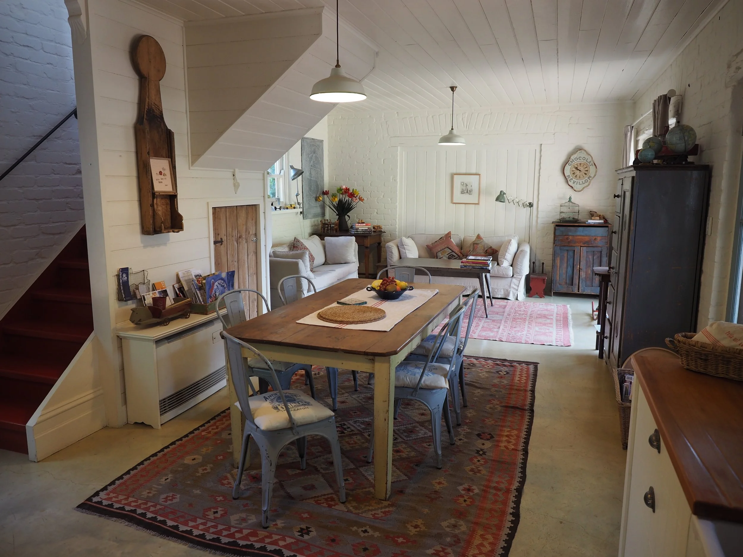 A farmhouse table, industrial chairs, Turkish rugs and rustic timber cupboards all come together in perfect harmony.