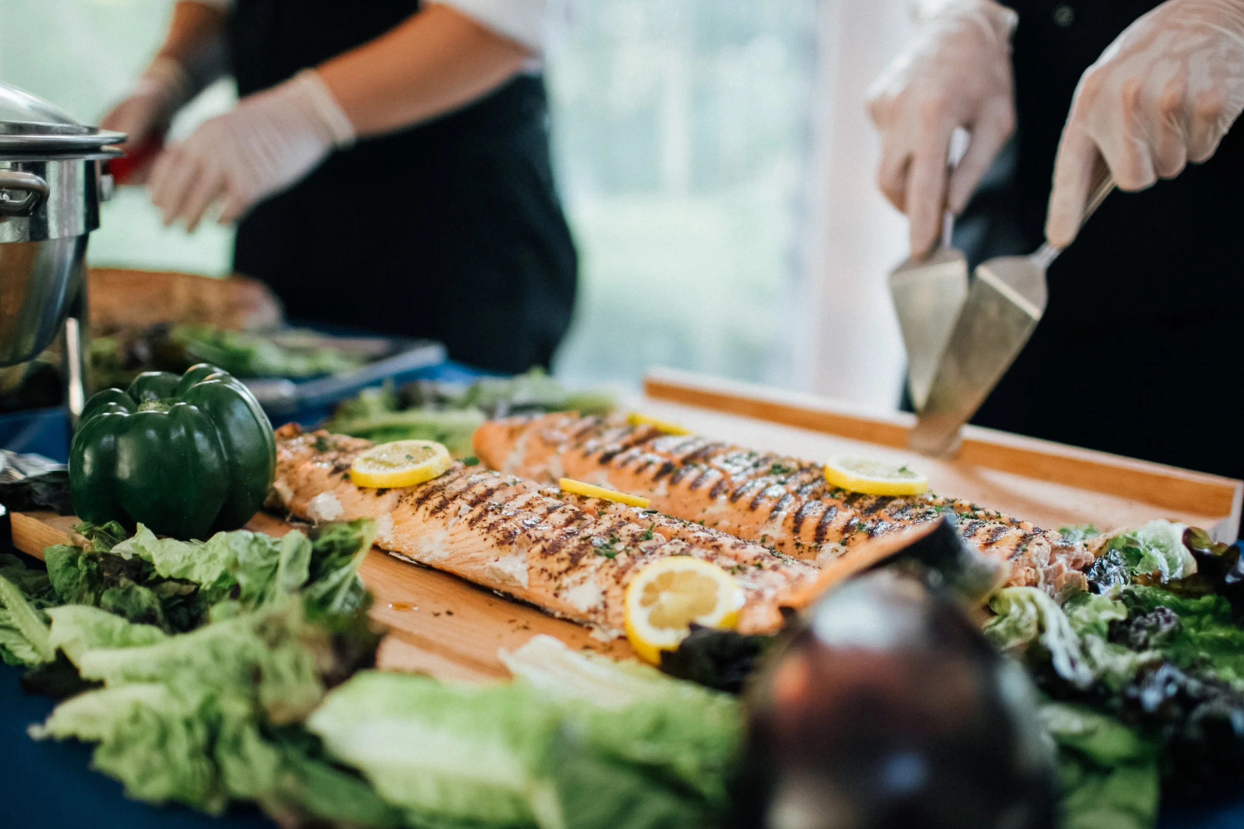 Chef preparing grilled salmon at action station