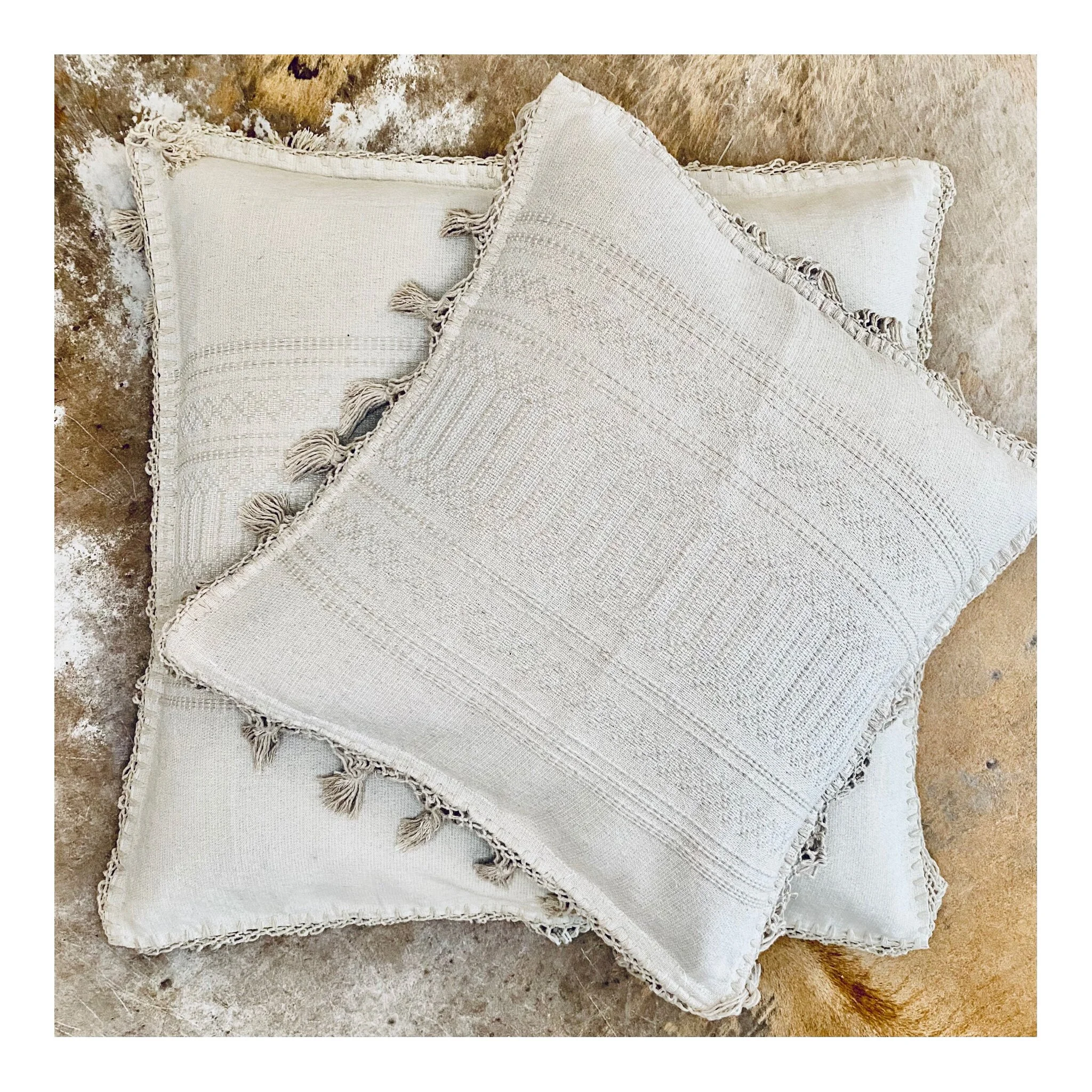 Two square pillows on top of each other.