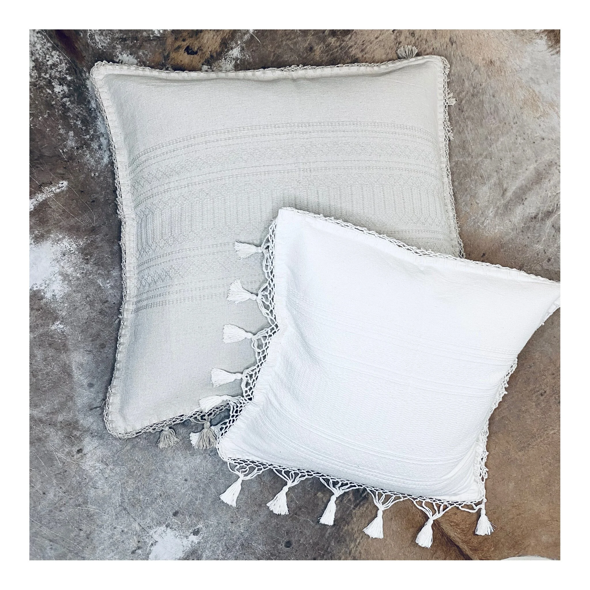 White square pillow on top of grey square pillow.