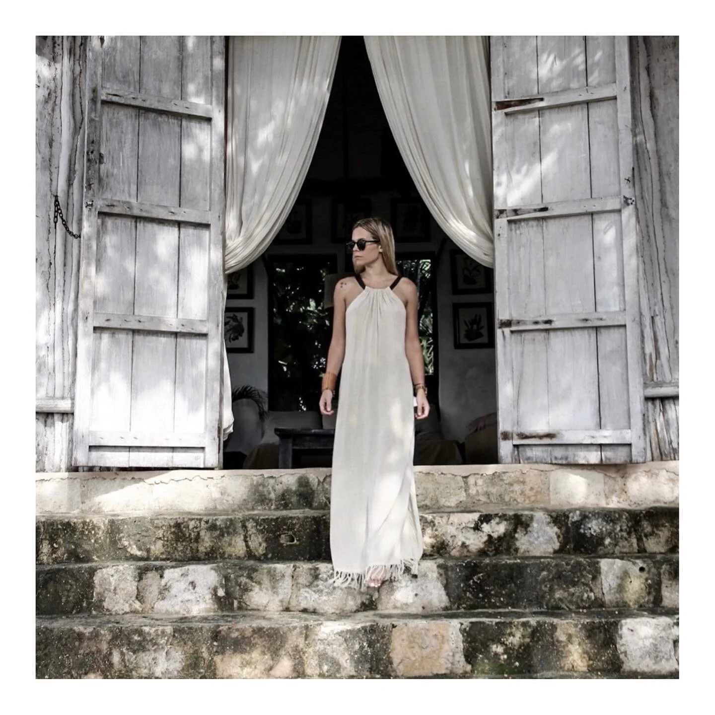 Woman wearing white dress in open doorway.