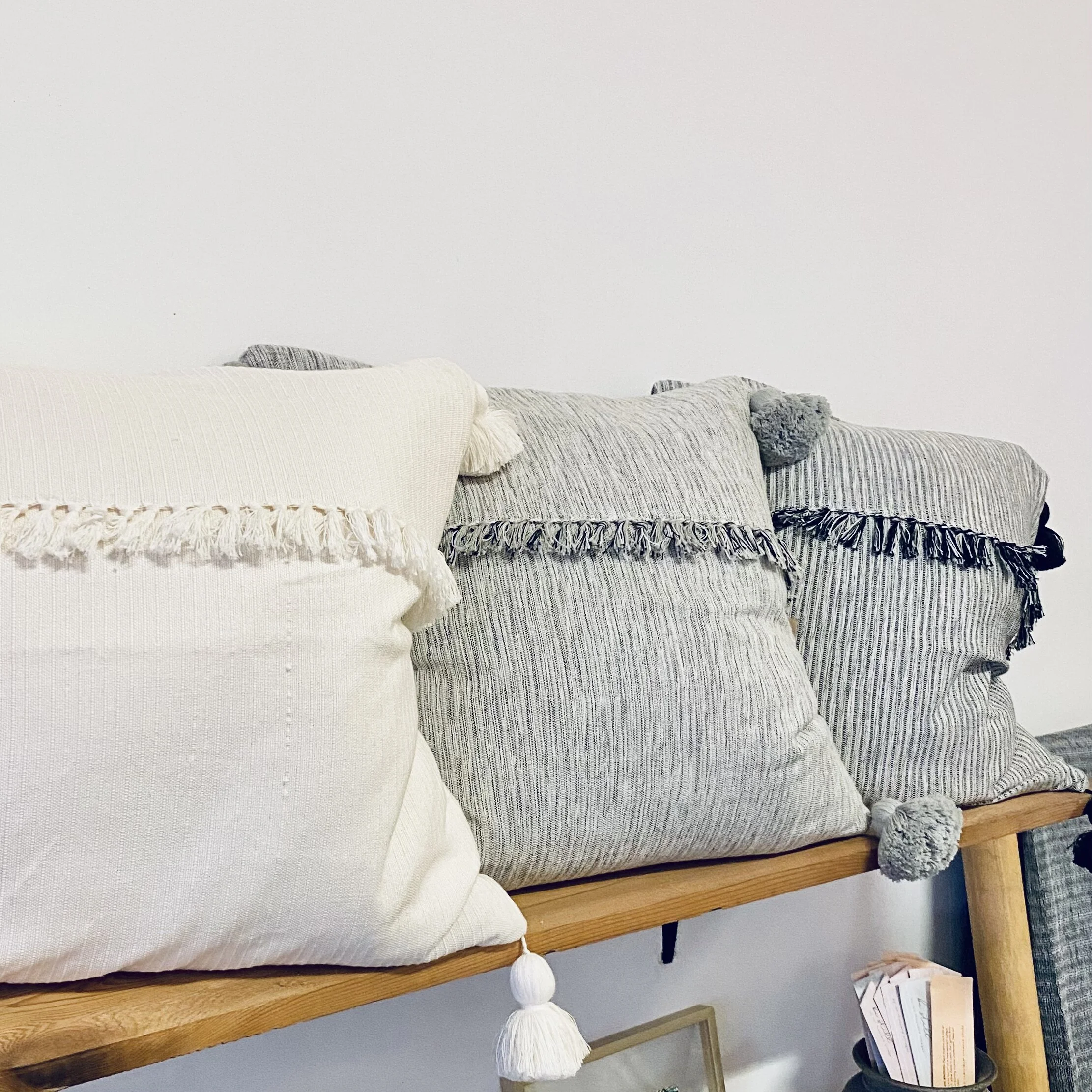 Three square cushions with tassels.