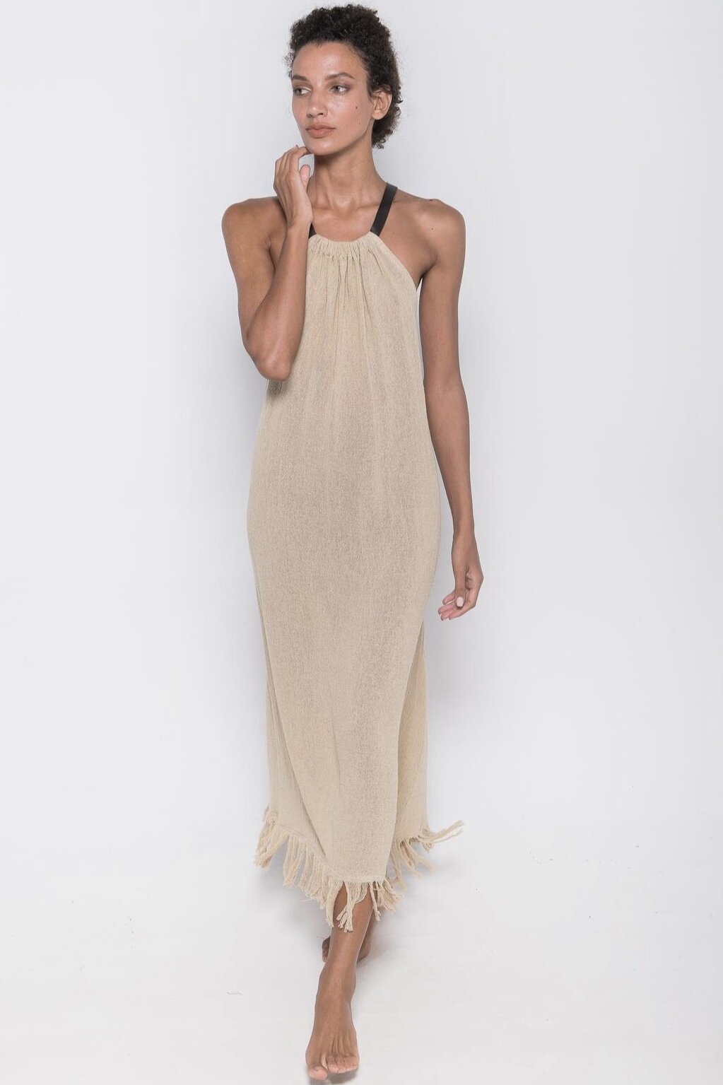 Woman wearing cream dress on white background.
