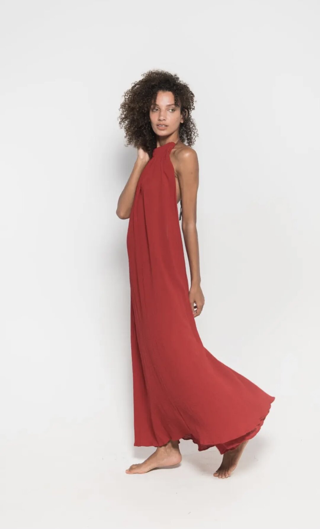 Woman wearing red maxi dress on white background in Miami Beach.