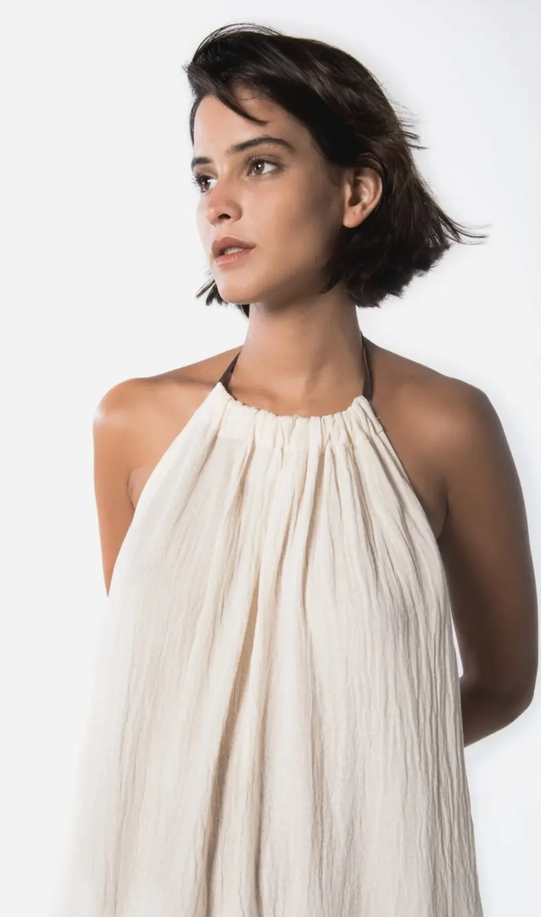 Woman wearing white halter dress on white background in Miami Beach.