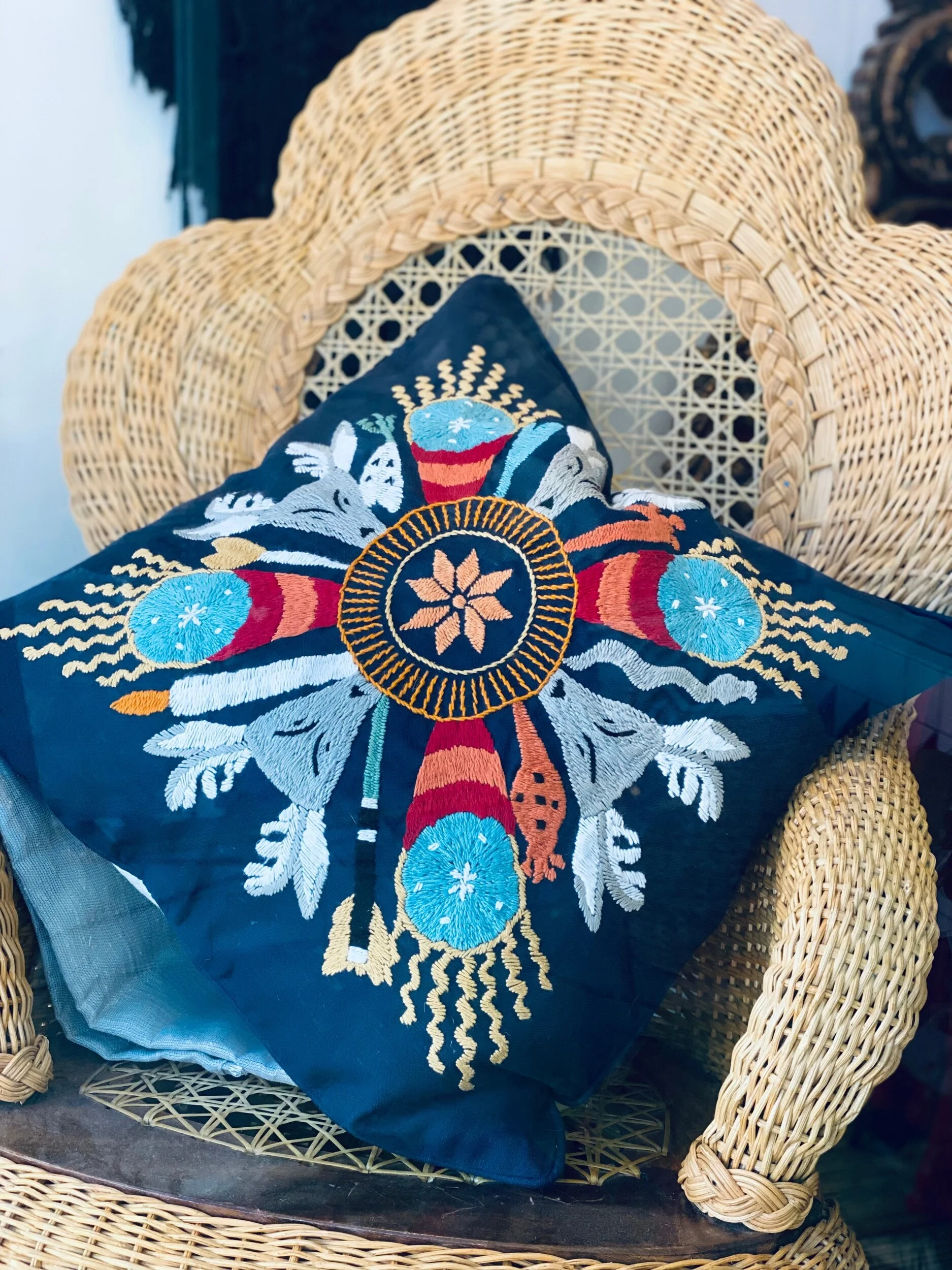 Blue pillow case with patterns on chair.