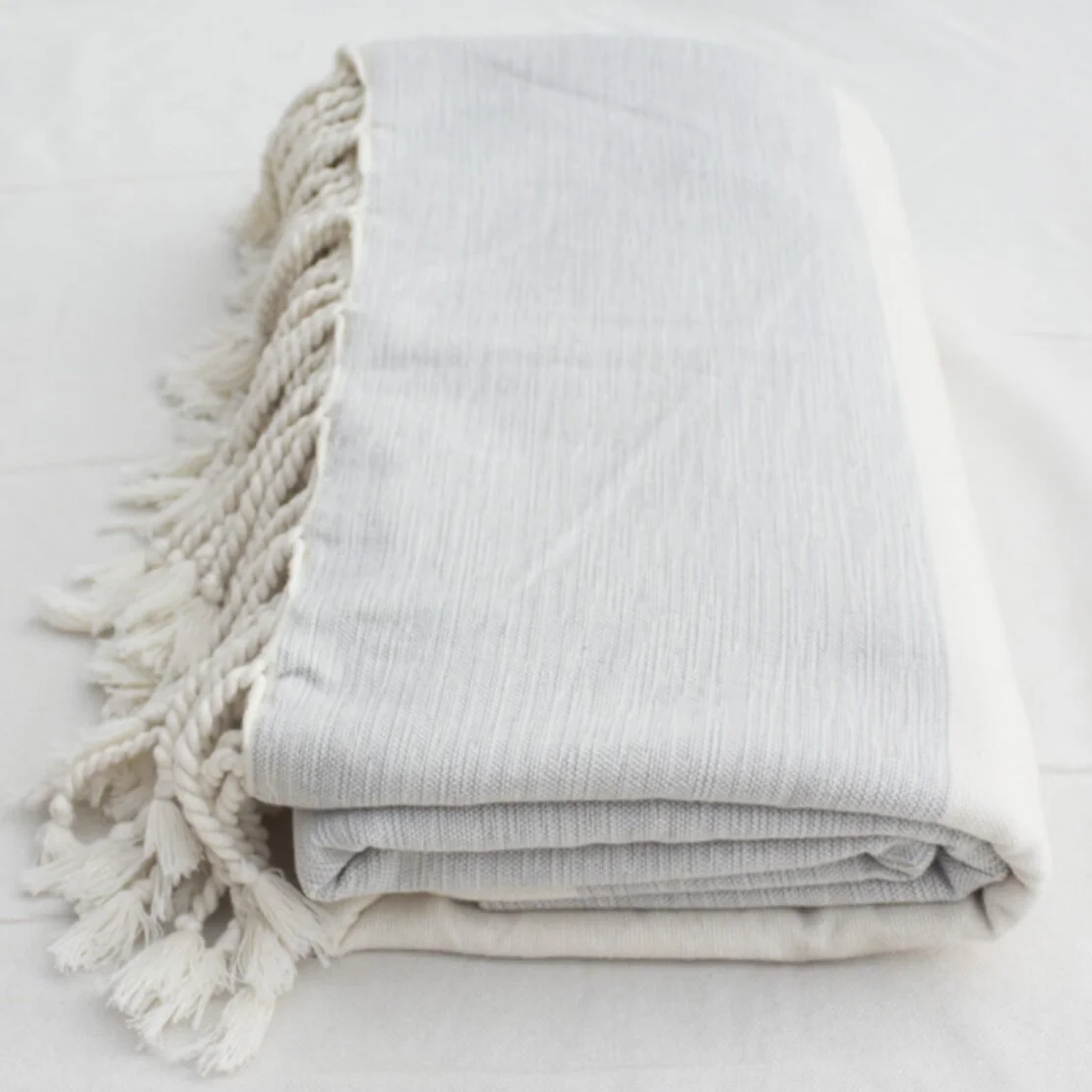 Rolled up off white bedspread.