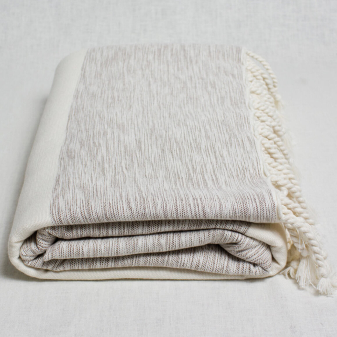 Rolled up off white bedspread.