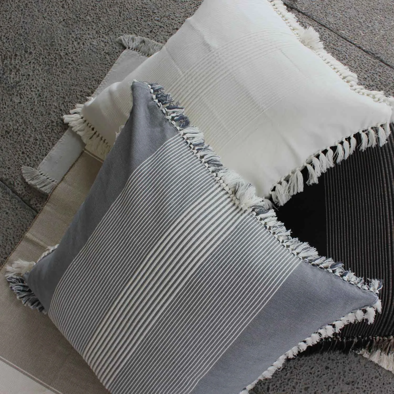 Grey and white striped pillow on white pillow.