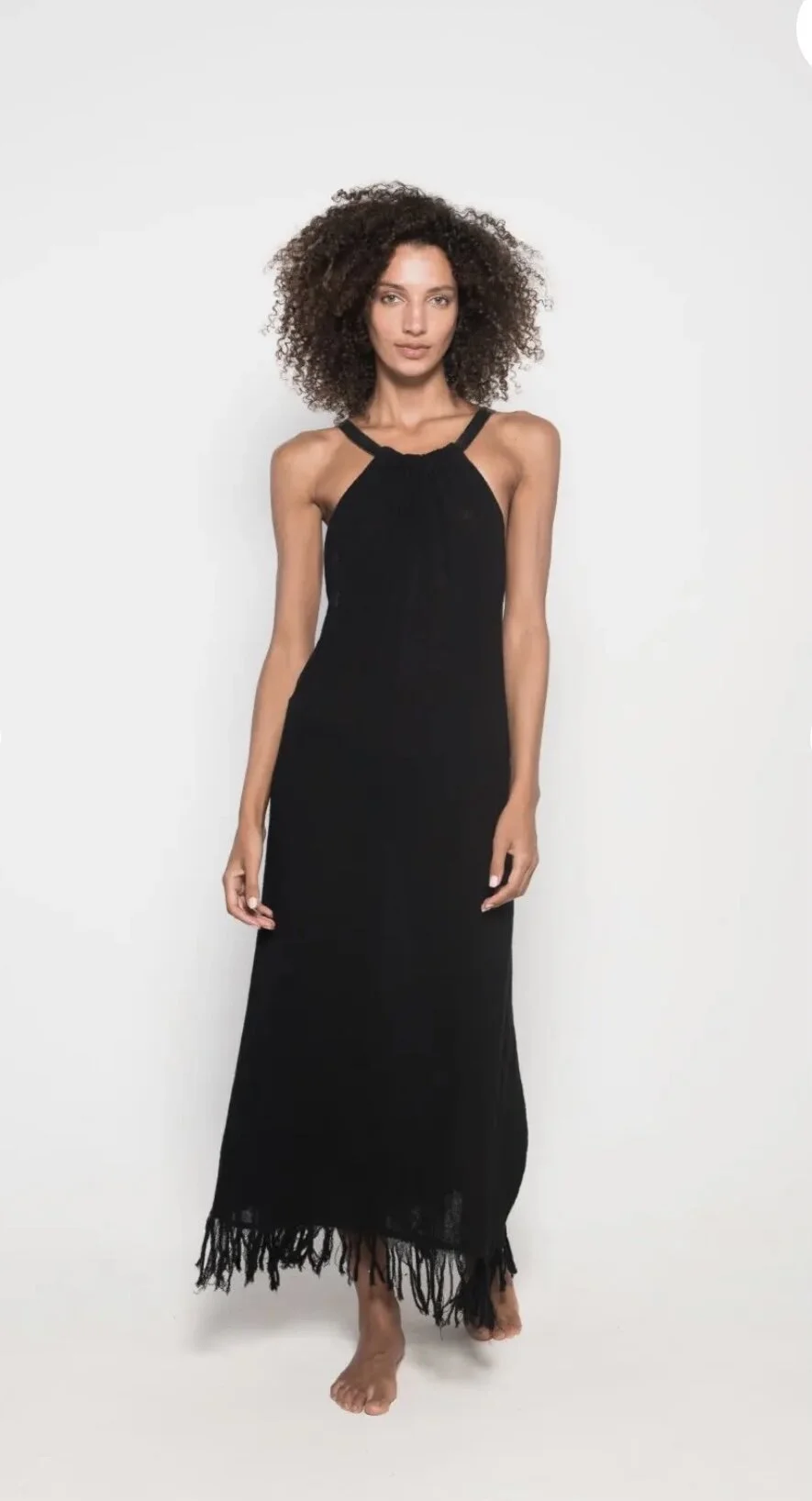 Woman wearing black maxi dress on white background.