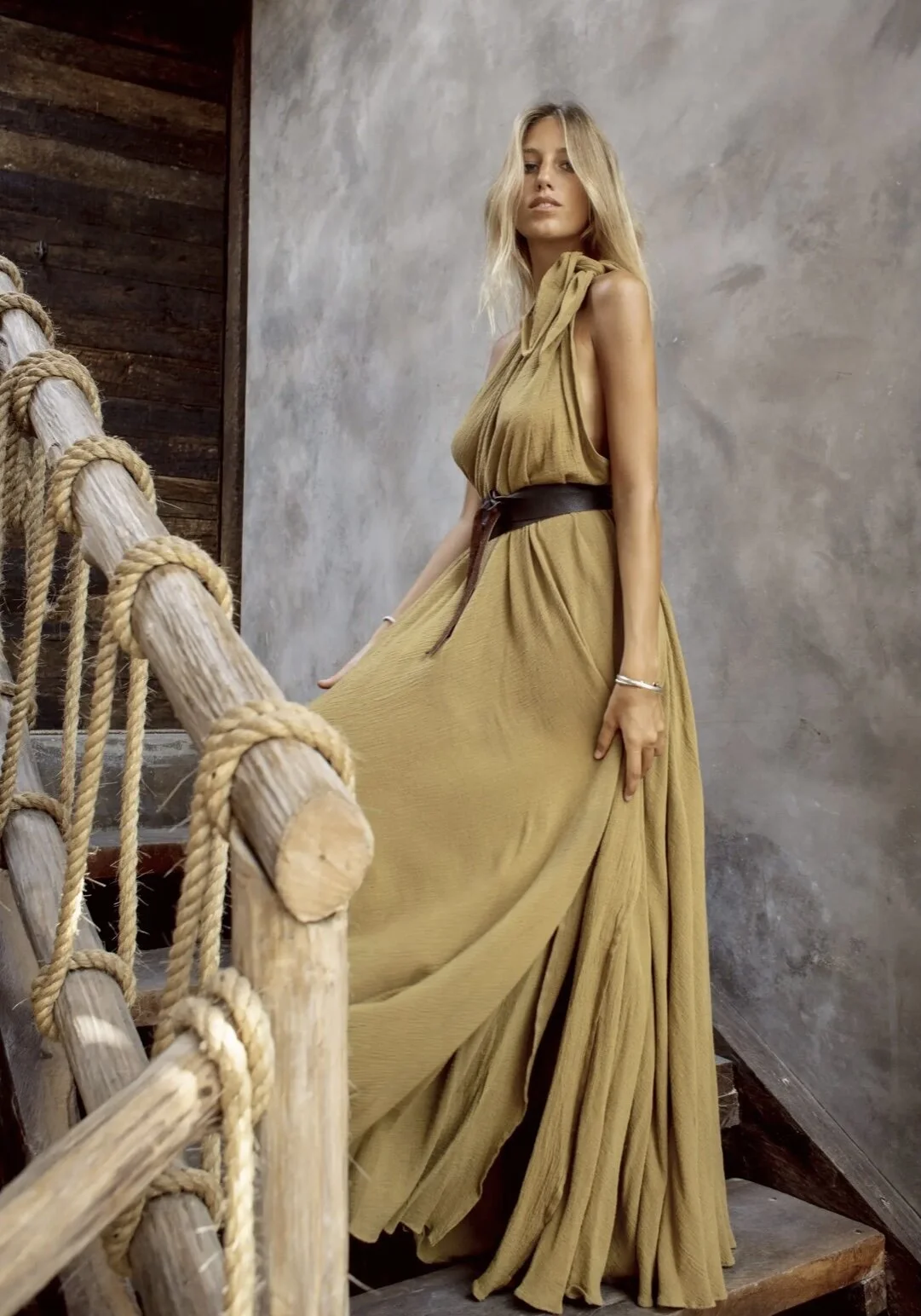 Woman wearing flowy maxi dress on stairs.