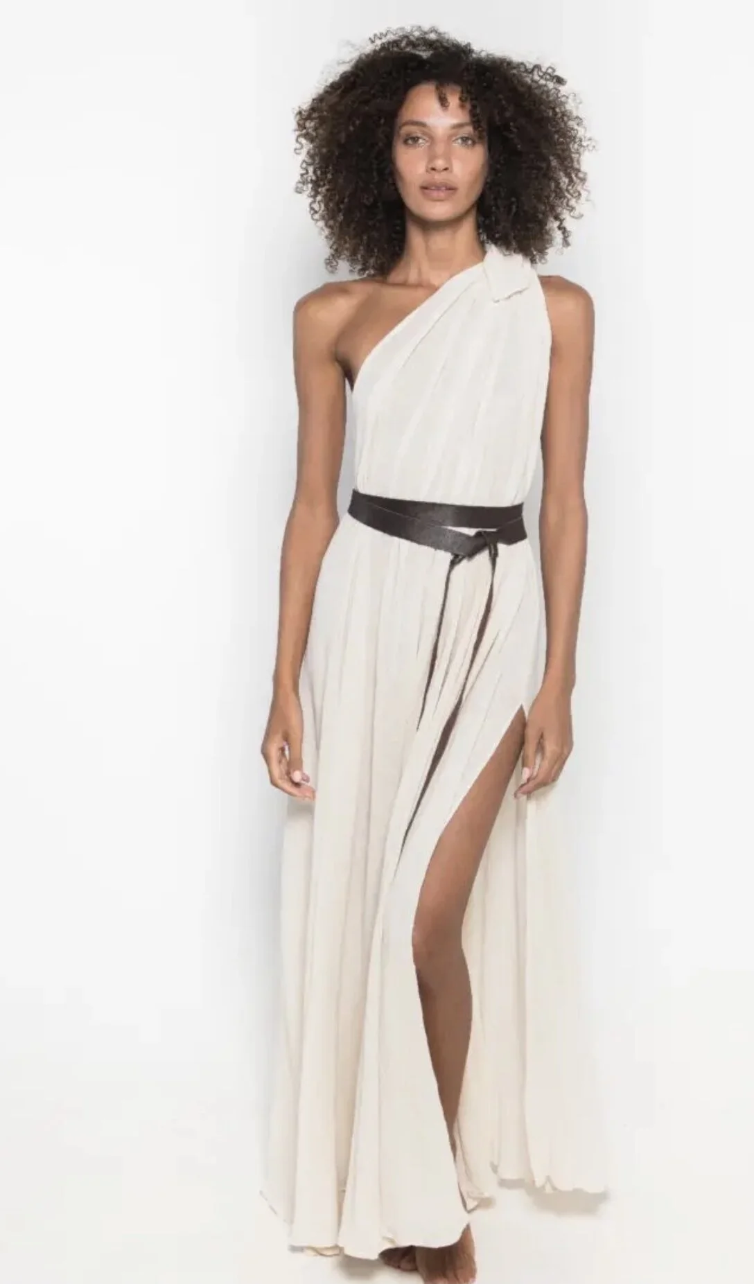 Woman wearing white flowy maxi dress on white background.