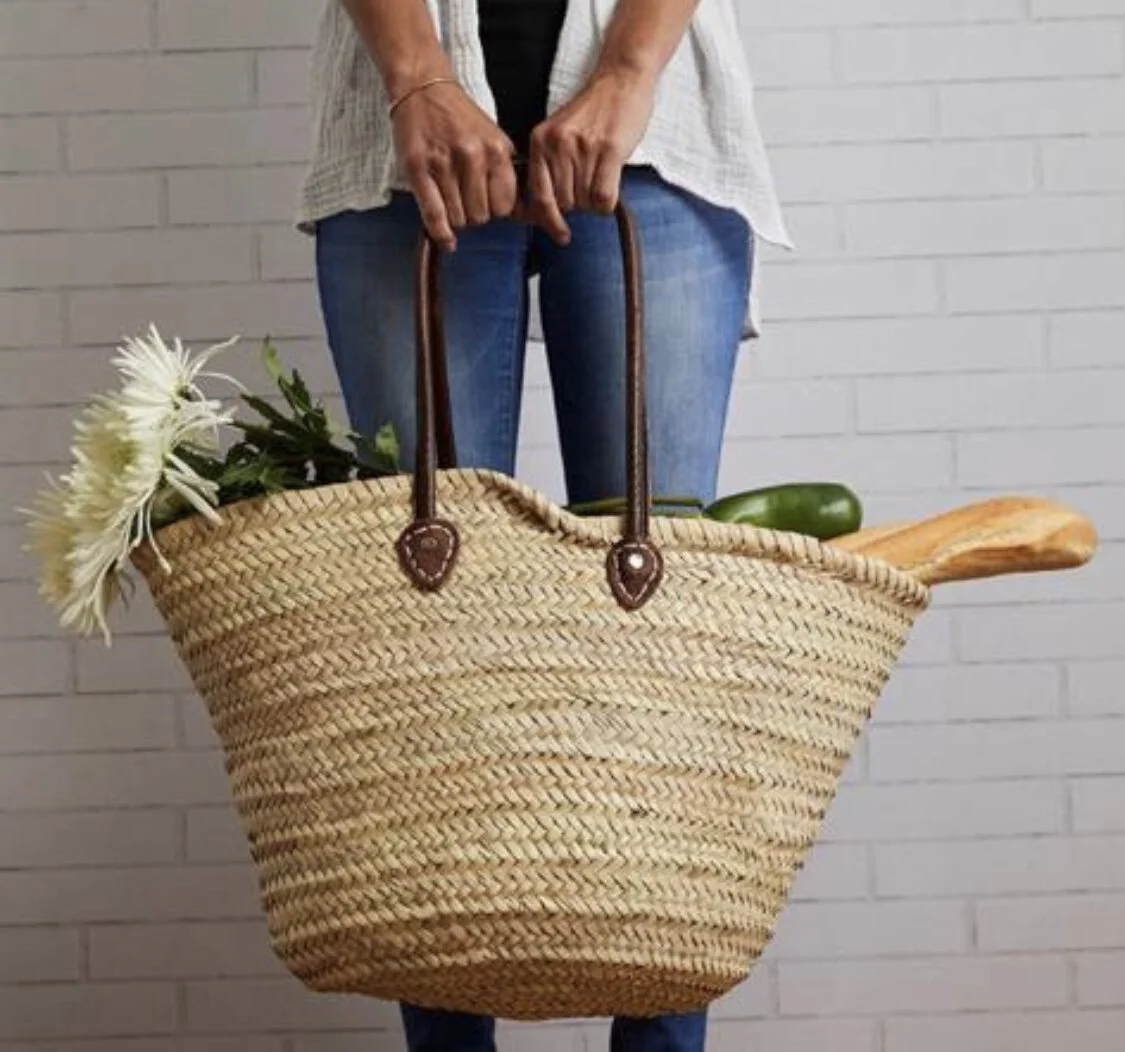Woman holding basket with groceries.