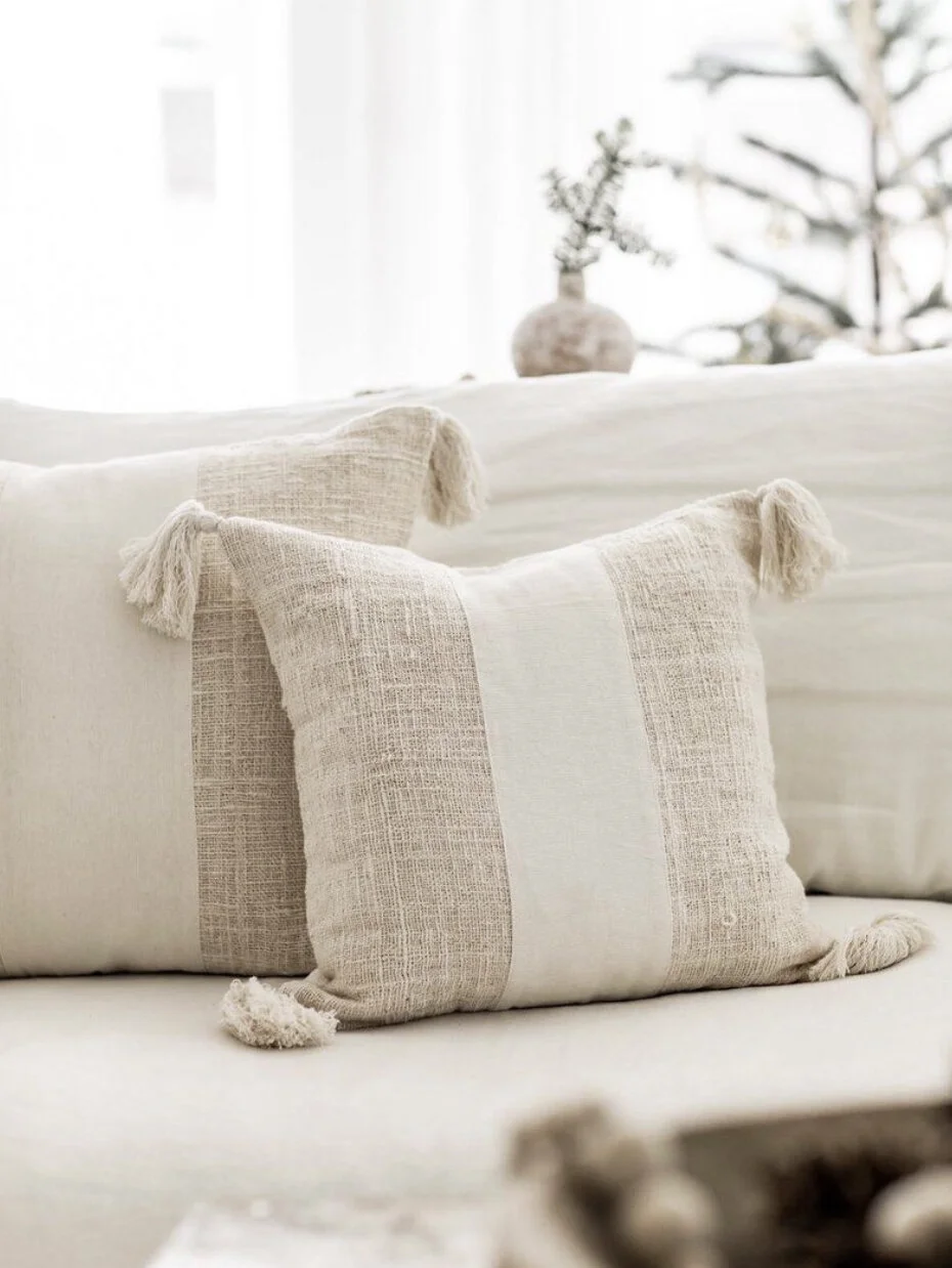 Light brown and white striped square pillow on sofa.