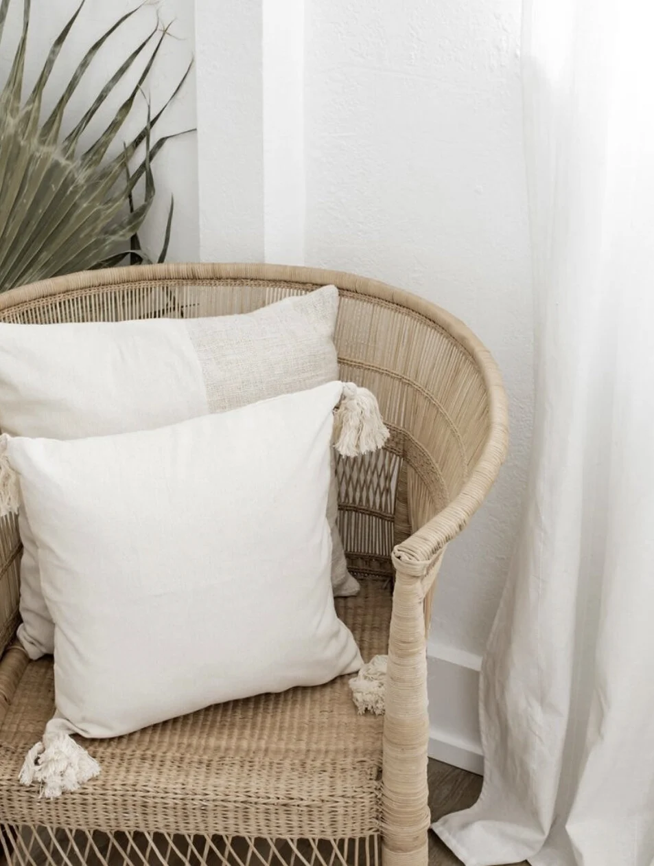 White pillow with 4 white tassels.