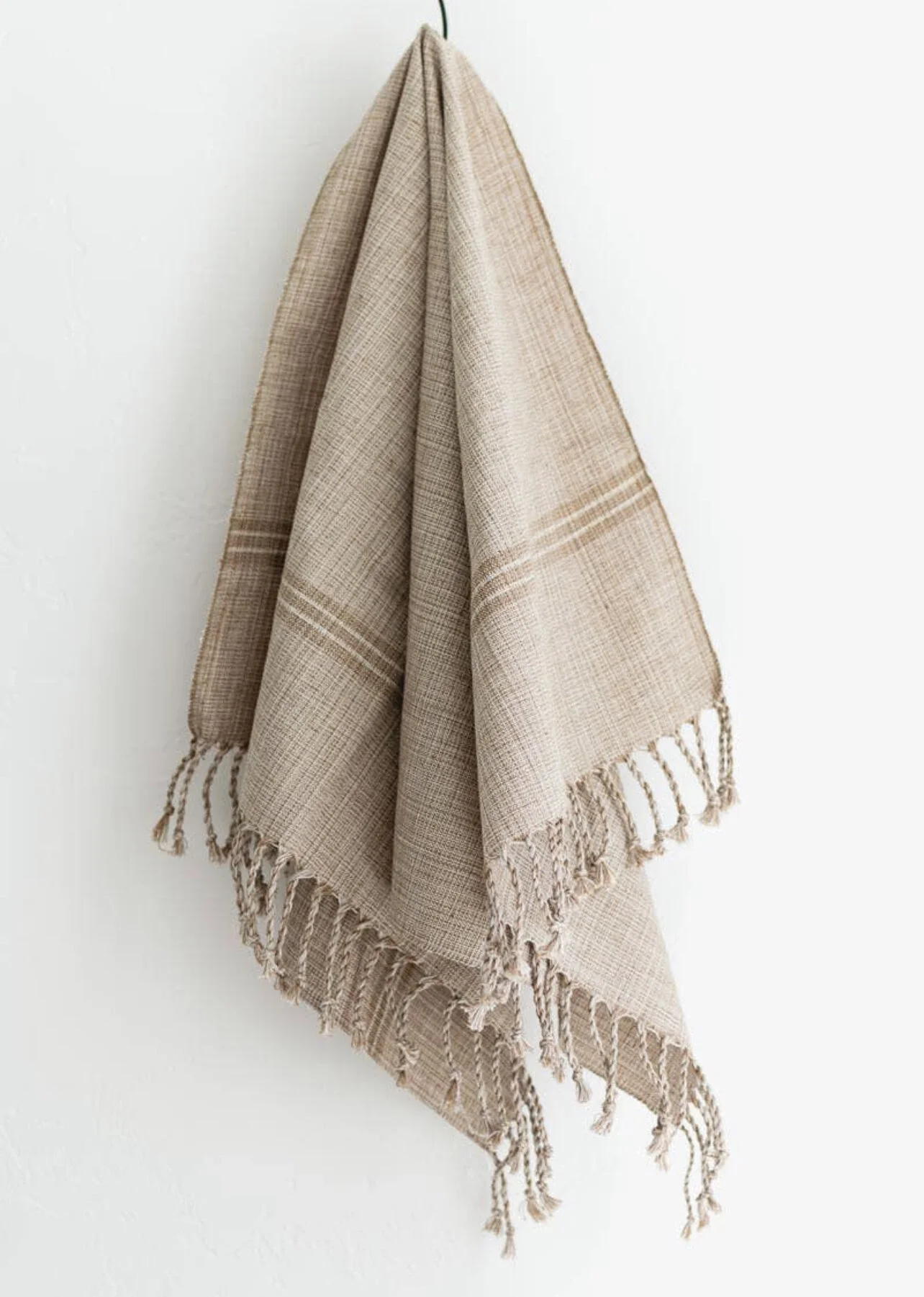 Light brown hand towel hanging on wall.