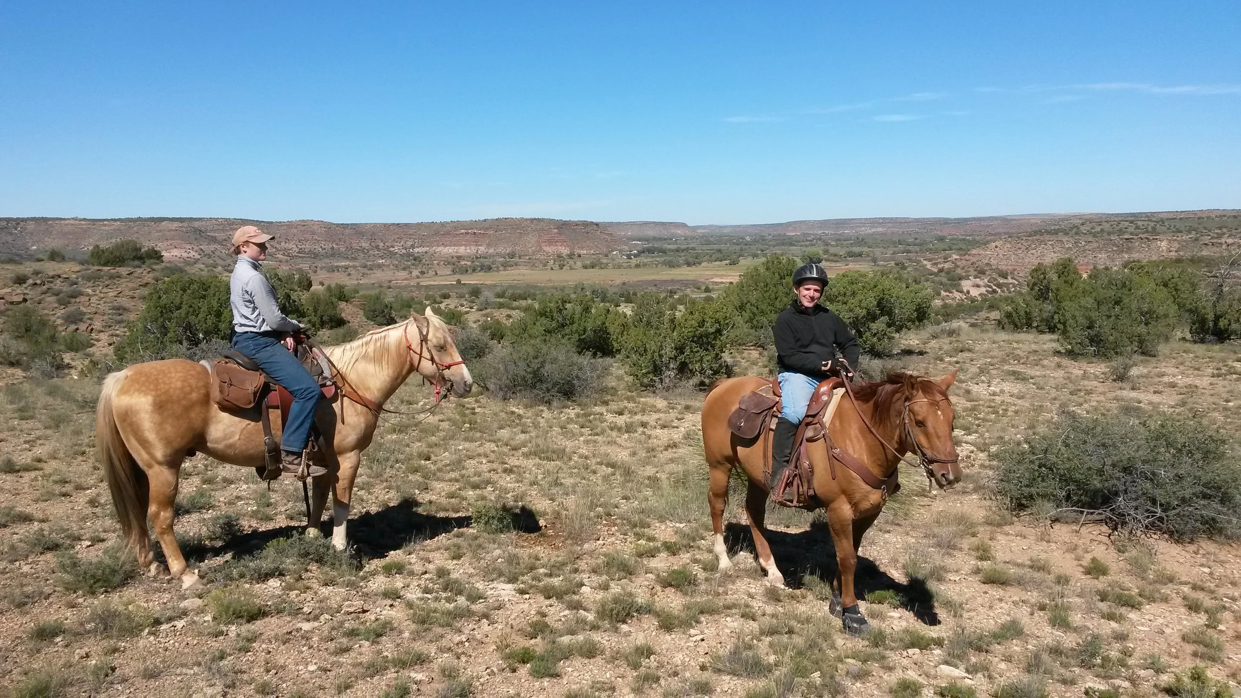 A trail ride in nice weather (left to right: Melanie on Johnny and Leo on Whiskey) with the Pecos Valley in the background. Ein Trailritt in herrlichem Wetter (links nach rechts: Melanie auf Johnny und Leo auf Whiskey) mit dem Pecos Valley im Hintergrund.
