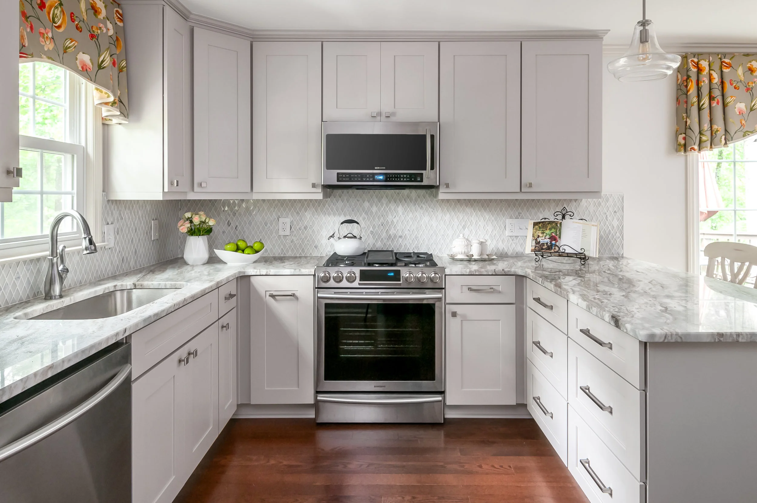New appliances and willow gray cabinetry create a clean feel to the heart of the kitchen. The hardwood floor from the adjoining family room was extended into the kitchen.