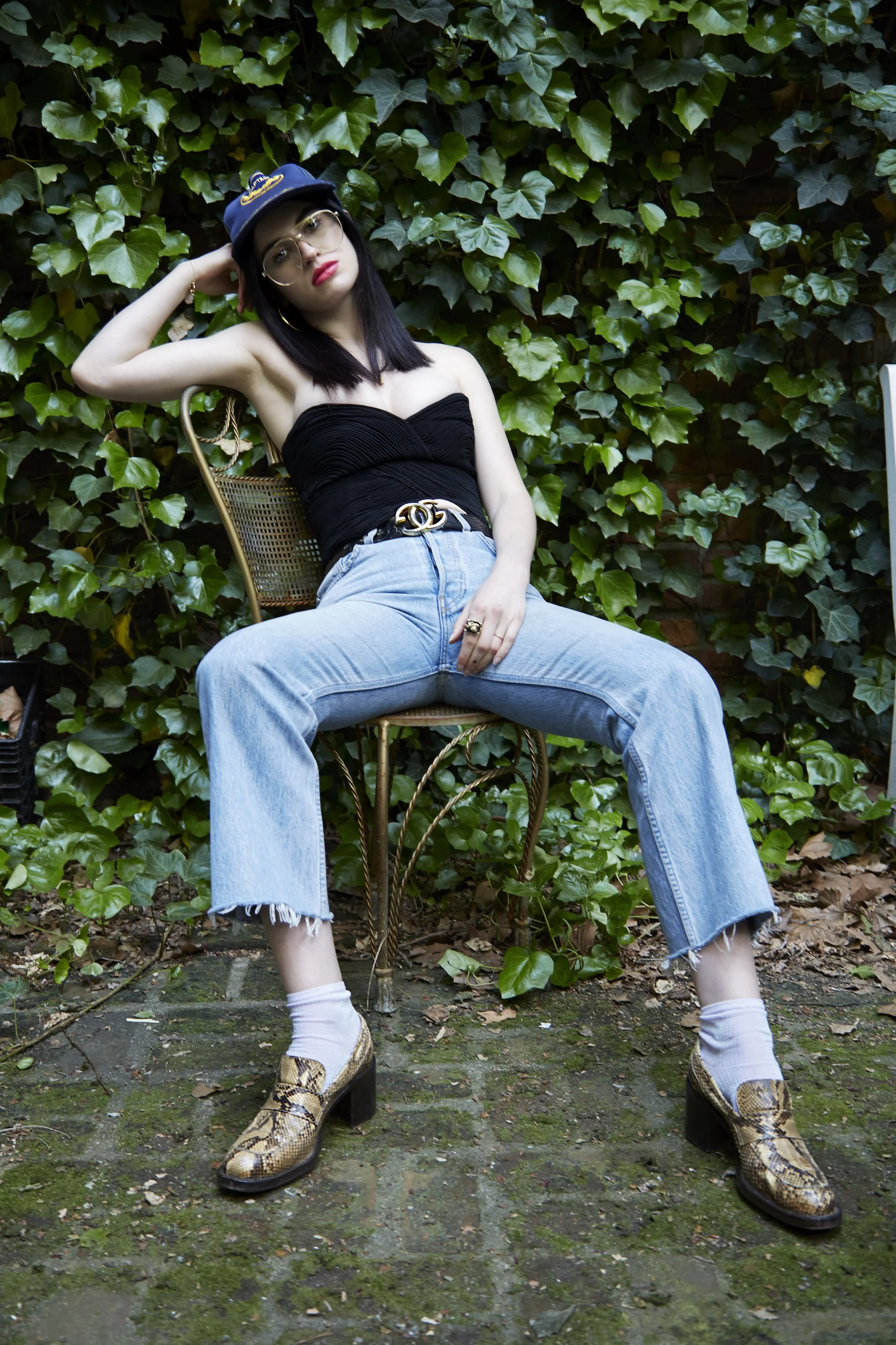 Bustier: Vintage Gianni Versace; Hat: Vintage; Belt: Vintage Gucci; Bracelet: Avocet Jewelry; Necklace, Black Stone Ring: Alibi; Brass Arco Ring: Pamela Love; Jeans, Shoes, Glasses, Earrings, Left hand Rings: Tali’s own