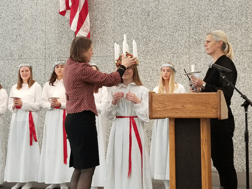 Swedish American Museum executive director Karin Moen Abercrombie places the St. Lucia crown on this year's Chicago Lucia, Jennifer Pearson.