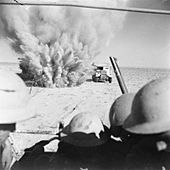 A_mine_explodes_close_to_a_British_truck_as_it_carries_infantry_through_enemy_minefields_and_wire_to_the_new_front_lines.jpg