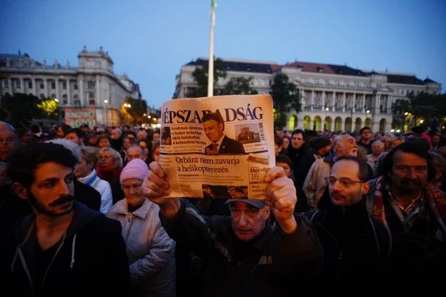A man holds up the last printed edition of Nepszabadsag during a demonstration organized to express solidarity with the Hungarian political daily Nepszabadsag in Budapest, Hungary, Oct. 8, 2016. Photo Courtesy: VOA News