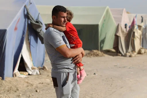 AHMAD AL-RUBAYE/AFP/Getty Images | Man and child in internally displaced persons (IDP) camp in Iraq