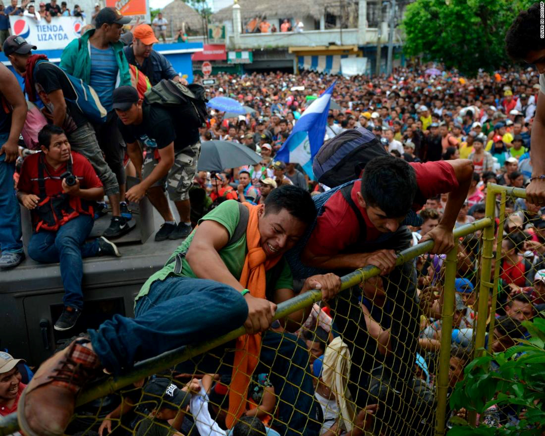 Honduran migrants rush the border fence in an attempt to cross into Mexico on Friday. Photo: CNN .