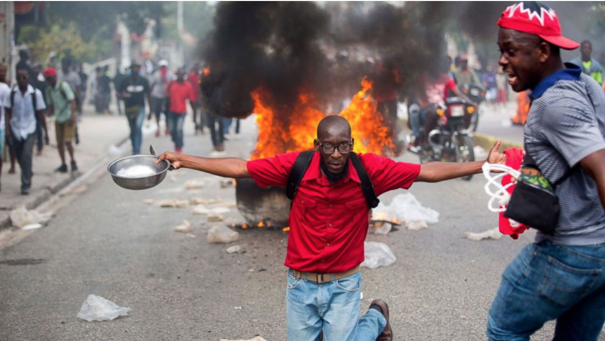 A demonstrator with a bowl and spoon to protest hunger in Haiti. Source: The Associated Press/ ABC News