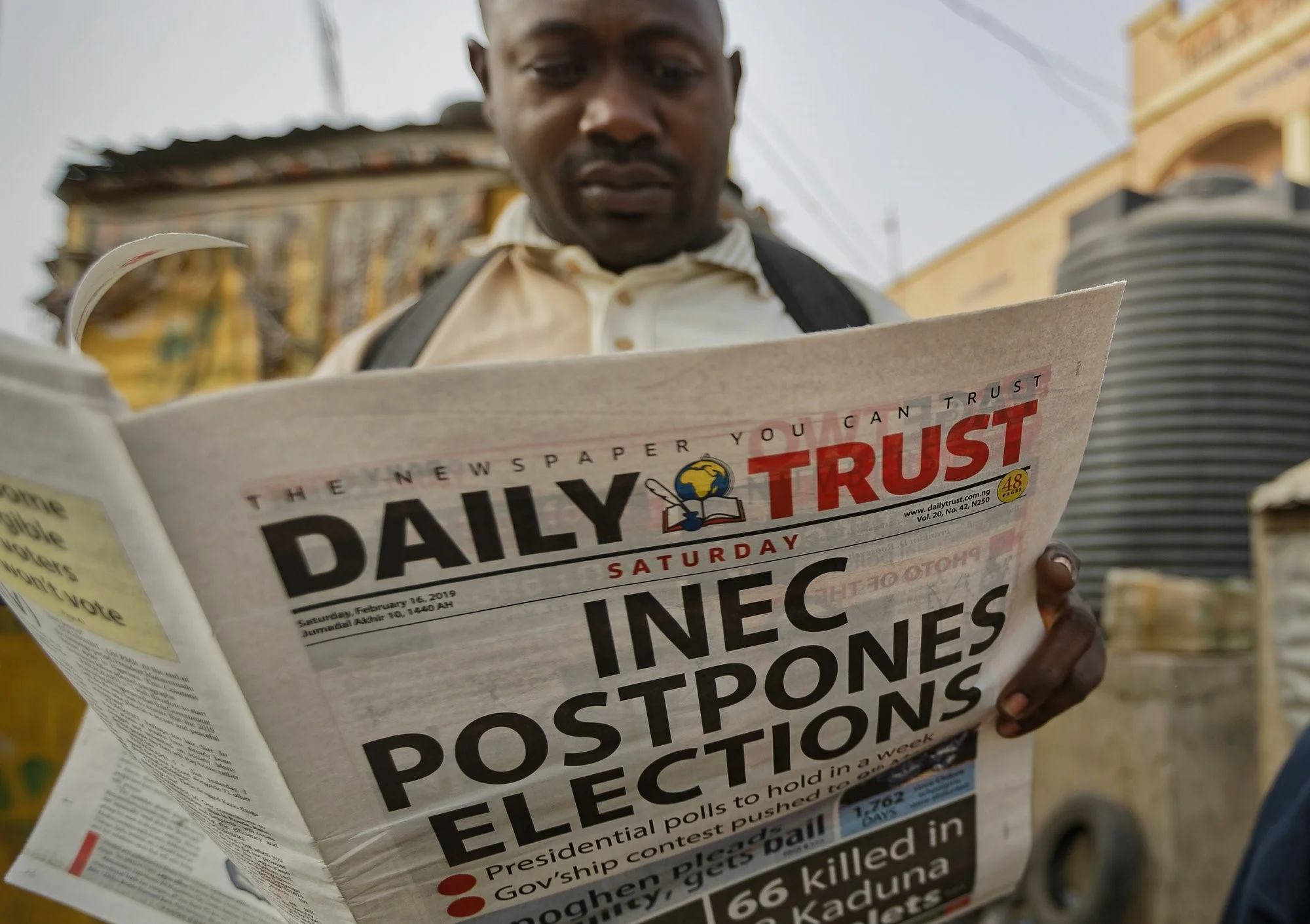 Man reads Newspaper the morning of the postponement of elections is announced. Photo: AP Photo/ Ben Curtis .