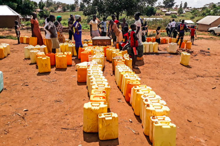 Residents of Kiryandongo refugee settlement camp in central Uganda line up at a borehole to receive water. Photo: Bill Oketch / AllAfrica .