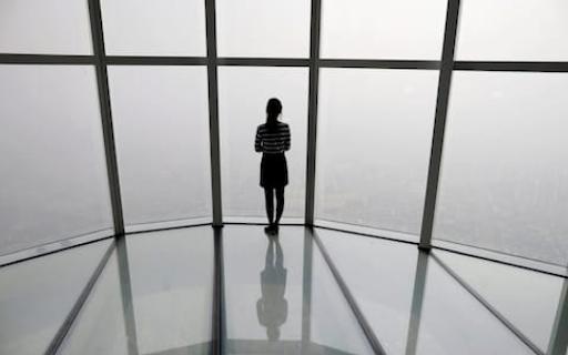 A woman looks out over the barely visible Seoul skyline. Photo: Kim Hong-ji/Reuters