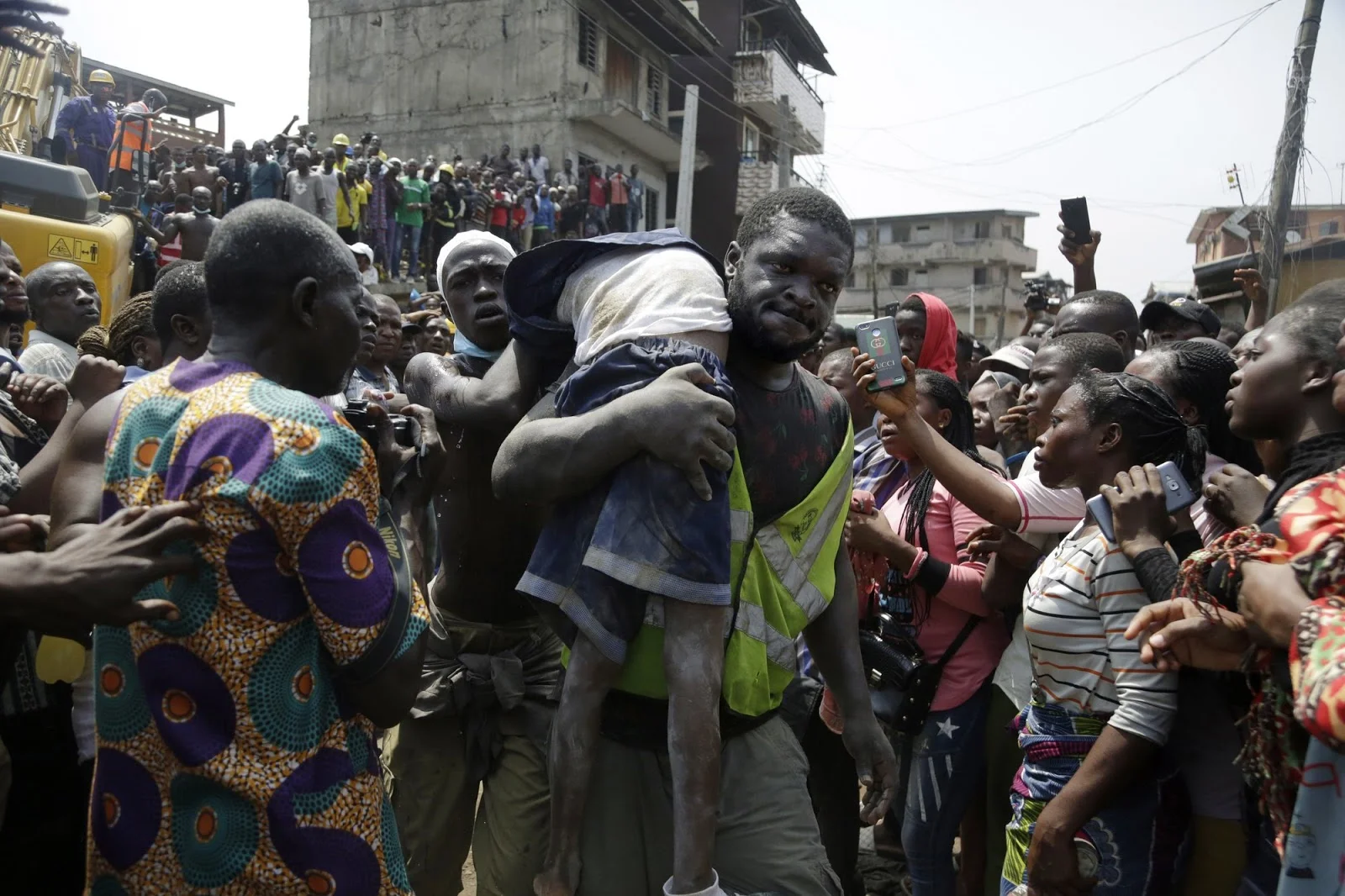 A rescue worker carries the unconscious body of a boy pulled from the rubble of the building collapse. Photo: Sunday Alamba/AP Photo